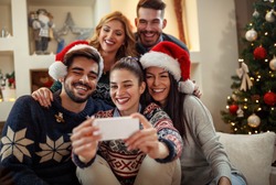 Young happy people making Christmas selfie