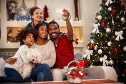 Cheerful African family making selfie together for Christmas