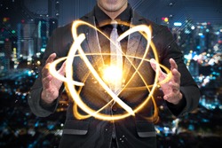 Quantum computer technology concept. Man in suit holding science yellow shining cosmic atom nuclear.