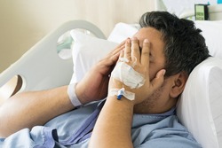 depressed patient asian man 40 on hospital bed with hand cover on his face, worry or mental health concept with copy space