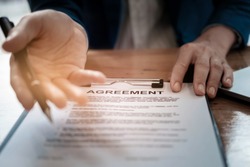 select focus agreement paper,estate agent gives pen and documents agreement with customer to sign contract. Concept agreement