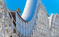 An old wooden construction rollercoaster against a blue sky