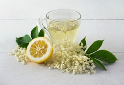 Refreshing drink made from elder flowers on awhite wooden table.