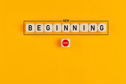 Starting a new beginning concept. The word new beginning on wooden cubes with a start button on yellow background. 