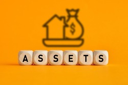 The word assets written on wooden cubes with assets icon on yellow background. Asset management or financial accounting concept.