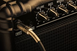 Black Guitar Amplifier with jack plugged in. Close up macro.