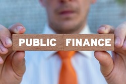Concept of Public Finance Audit. Businessman holding two wooden blocks with public finance words. Government Public Finance Department or Tax Office.