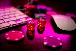 Online casino. Online poker. On the table there are game pieces and dice next to the keyboard. Game chips for betting in gambling. Dice. Poker chips.