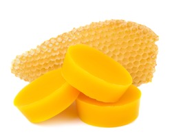 Pieces of natural beeswax and a piece of honey cell are isolated on a white background. Beekeeping products. Apitherapy