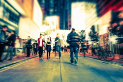 Blurred image of people moving in crowded night city street. Art toning abstract urban background. Hong Kong