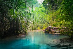 Jungle landscape with flowing turquoise water of Erawan cascade waterfall at deep tropical rain forest. National Park Kanchanaburi, Thailand