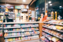 blur photo background of snacks and consumer product colorful in supermarket shop front shelf at counter cashier's desk. Mini-mart convenience stores are a new alternative for the urban people concept