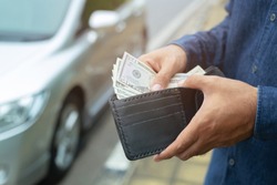 Businessman Person holding a wallet in the hands of take money out of pocket stand front car prepare pay by installments - insurance, loan and buying car finance concept insurance, payment a car