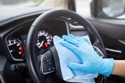 car wash,  worker hand wear glove cleaning console steering wheel with microfiber cloth blue. hygiene prevention  antibacterial of corona virus outbreak.