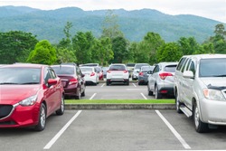 Car parked in asphalt parking lot and empty space parking  in nature with trees and mountain background .Outdoor parking lot with fresh ozone and eco friendly green environment concept