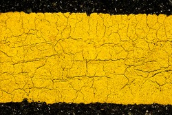 Texture of asphalt road with yellow line background, pattern of old cracked yellow painted on asphalt surface can use for background and wallpaper, close up