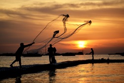 fisher man net with sunset in the sea