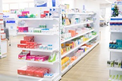 At the chemist, Medicines arranged in shelves, Pharmacy drugstore retail Interior blur abstract backbround with medicine and healthcare product on cabinet with ืneon light with vaccine.