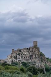 Craco city against dramatic sky at dusk. Craco is a ghost town in the southern Italian region of Basilicata. It was abandoned towards the end of the 20th century due to an earthquake. 