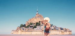 Rear view of woman looking at Le Mont Saint Michel- Normandie in France