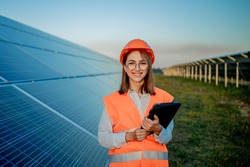 Inspector Engineer Woman Holding Digital Tablet Working in Solar Panels Power Farm, Photovoltaic Cell Park, Green Energy Concept.