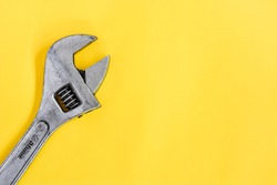 top view old adjustable wrench isolated yellow background, copy space
