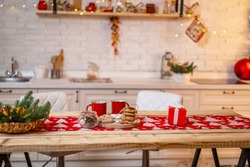 Merry Christmas! Interior decorated kitchen with Christmas decor and Christmas tree. table with hot drinks in fancy mugs with cookies and gingerbread. Christmas in kitchen table setting.