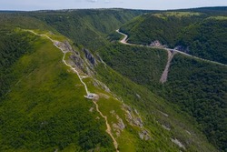 Aerial view of the Skyline Trail in Cape Breton Highlands National Park, Nova Scotia. The winding Cabot Trail road is visible in background.