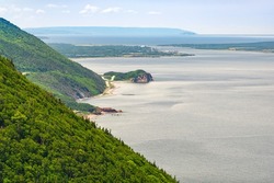Scenic view of Cabot Trail in Cape Breton Island, Nova Scotia, Canada on a sunny summer day. The town of Chticamp is visible in background