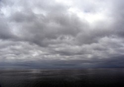 Gushing sea on a cloudy day. Horizontal view of dramatic overcast sky and  sea. Fifty shades of blue.