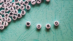 Word word made of round plastic blocks on the table mint color.
