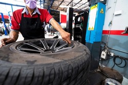 A set of workers remove the tire from the rim with a tire-removing machine device,Mechanic repairing tire