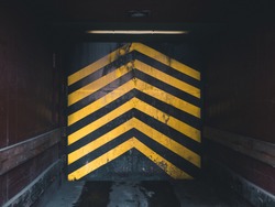looking inside an industrial elevator in a factory, with yellow arrows pointing upwards