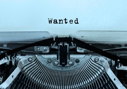 Wanted printed on a sheet of paper on a vintage typewriter . writer, journalist.