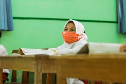 portraits of students studying in class using health masks