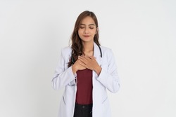 beautiful doctor in white uniform holding chest and eyes closed with patient expression