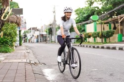 asian female cyclist in sport clothing and helmet