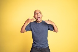 bald young man opening his mouth with spiciness expression