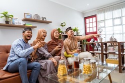 muslim friend sitting in livingroom enjoy watching tv