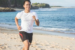 portrait of Handsome asian man running on the beach