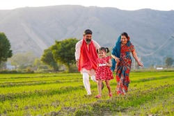 Indian farmer with wife and daughter at agriculture field.
