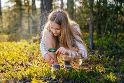 Teenage girl holding magnifying glass explores nature and the environment. Future profession ecologist or biologist.