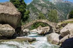The ancient roman stone bridge at Puntid high over the Foroglio village in the Maggia valley, Tessin, Switzerland