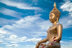 Full body old Buddha statue with raw of Brass. Two Hand of buddha statue with stamp on chest with the fresh sky background. Believe, Culture, Traditional. Concept of Buddhist believe and merit.