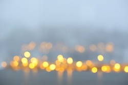 Golden bokeh on a gray background, blurred urban twilight. Abstract blurred background with beautiful bokeh