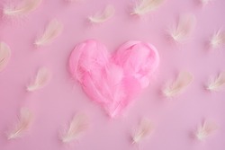 Heart shape made of bright pink feathers, fuzz and fluff on pink background. Pattern of white feathers. Concept Valentines day, romantic, love, lovers wallpaper