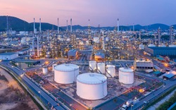 Aerial view Refinery and oil storage tanks at dusk and night. Petrochemical and energy oil industries.
