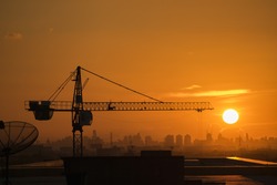 Silhouette Crane in building construction site on Sunset Background 