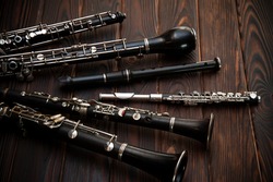 Woodwind instruments lie on a wooden surface