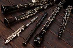 Woodwind instruments lie on a wooden surface. View from above